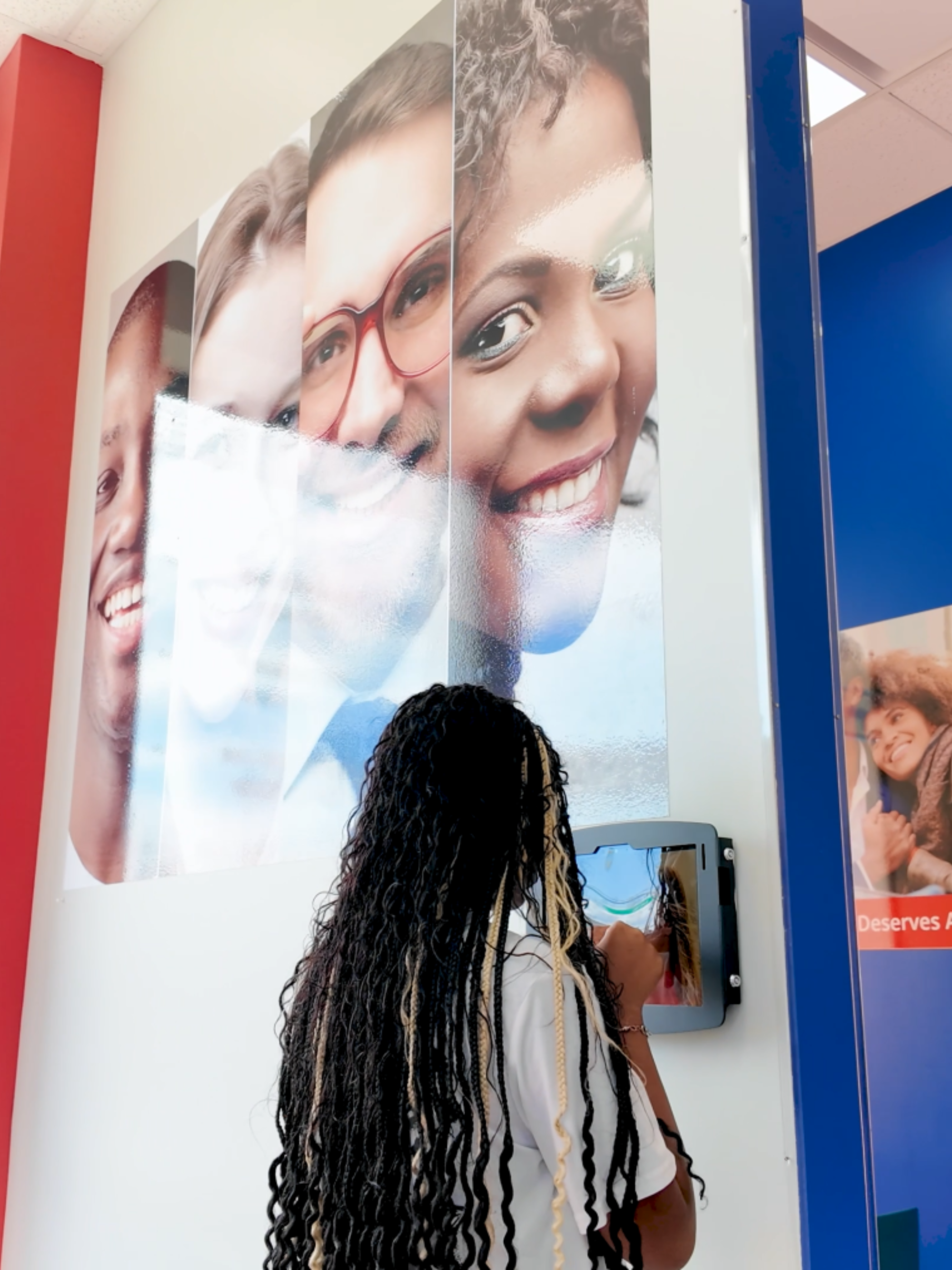 Orthodontic assistant looking at a display of family photos in a New York dental clinic.