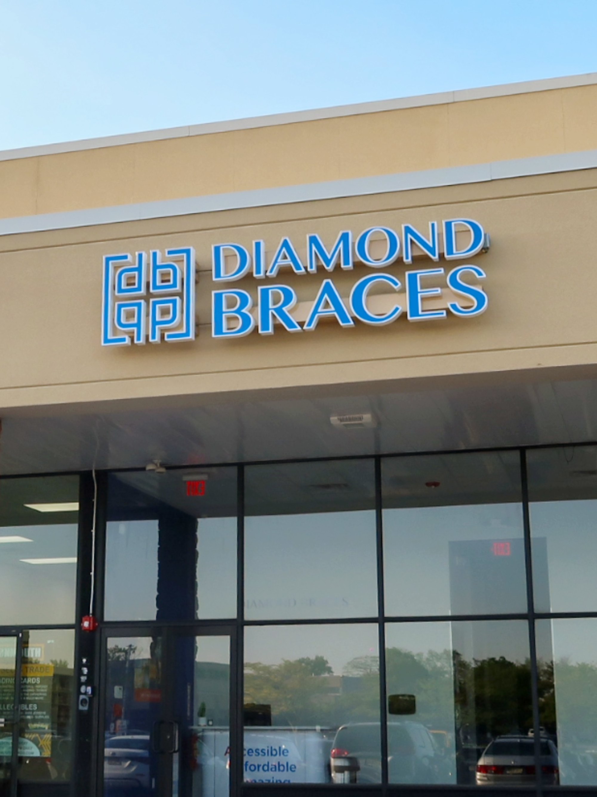 Diamond Braces store front with clear glass windows and blue signage for Invisalign and metal braces.
