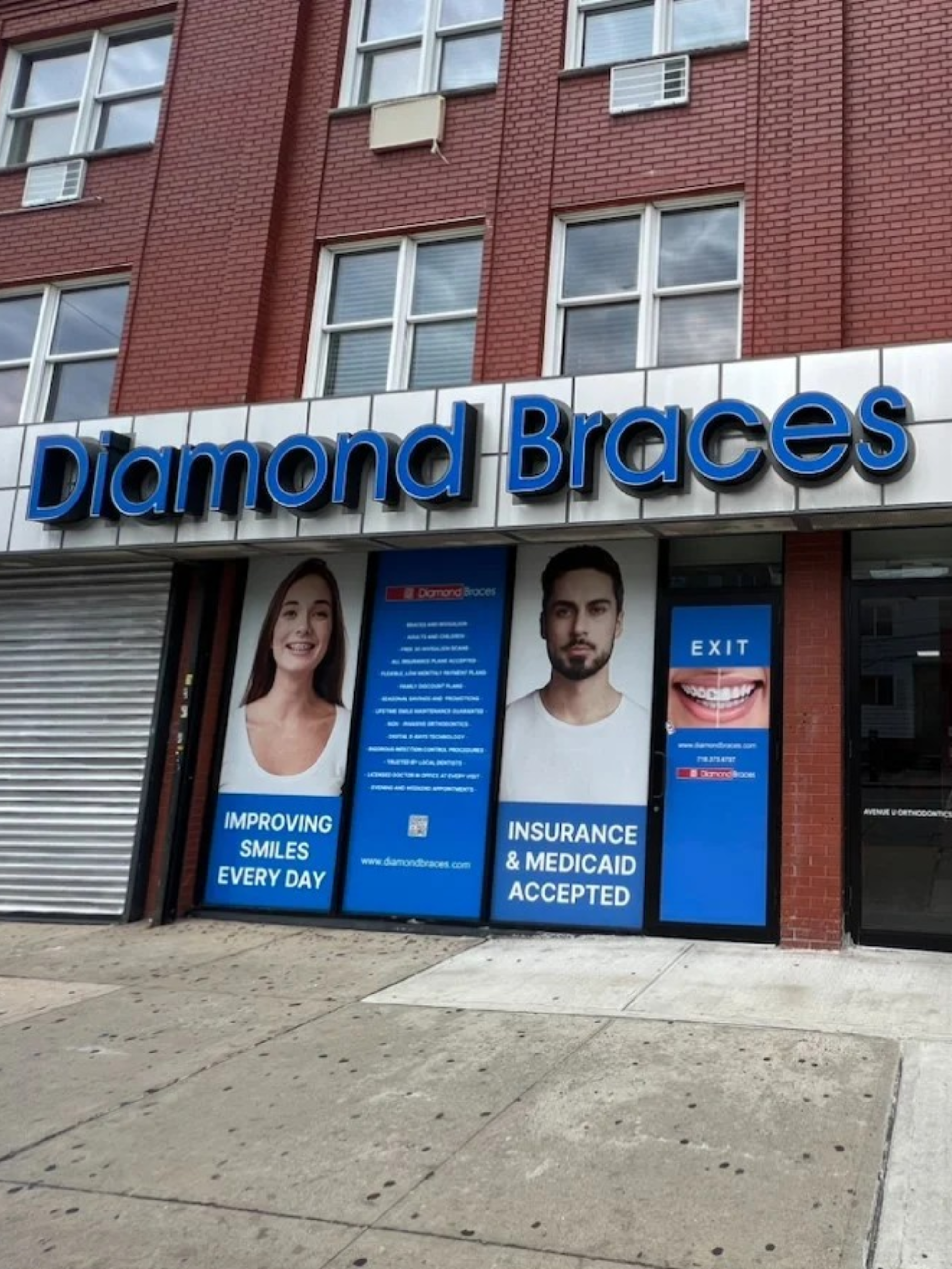 Diamond Braces dental clinic entrance with promotional posters on a brick building in Brooklyn.