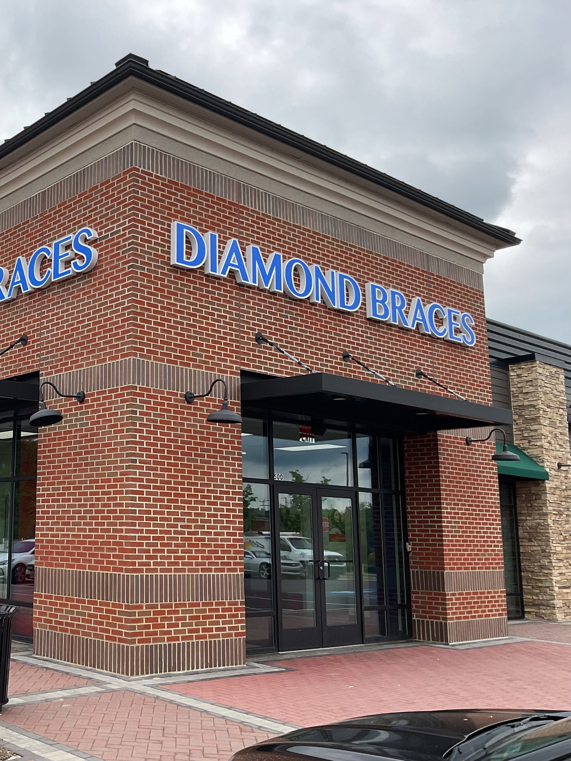 Diamond Braces dental office with a brick facade and blue signage for Invisalign.