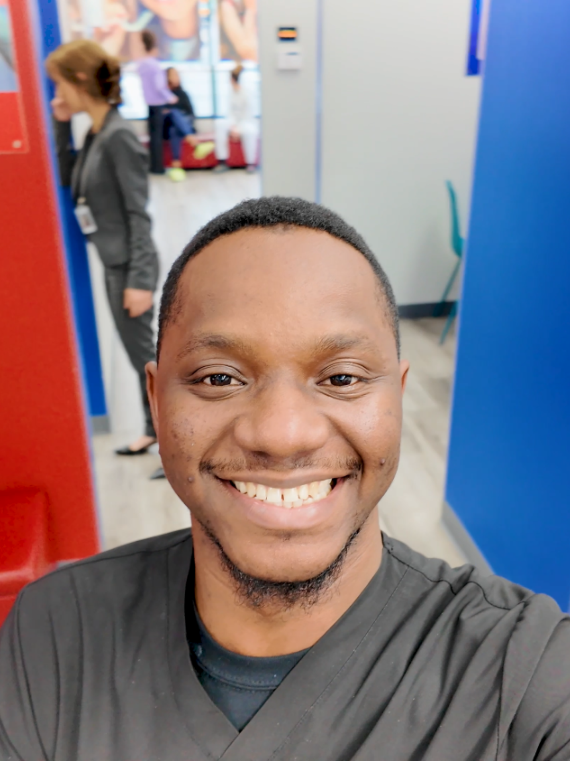 Dental hygienist smiling in a casual setting with colorful walls inside a Diamond Braces dental office.