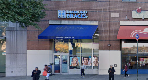 Diamond Braces dentist office store front with people walking by.