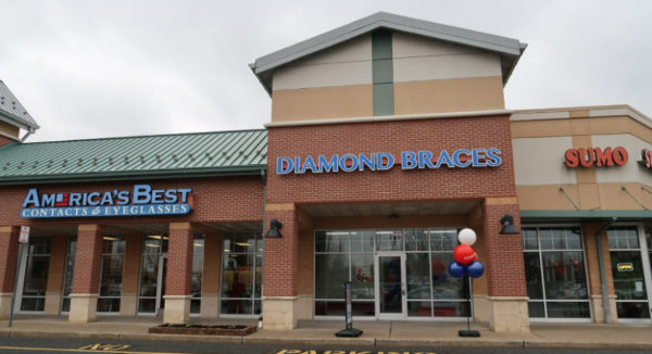 Commercial building with multiple store signs including a Diamond Braces orthodontist office location in Cinnaminson, New Jersey.