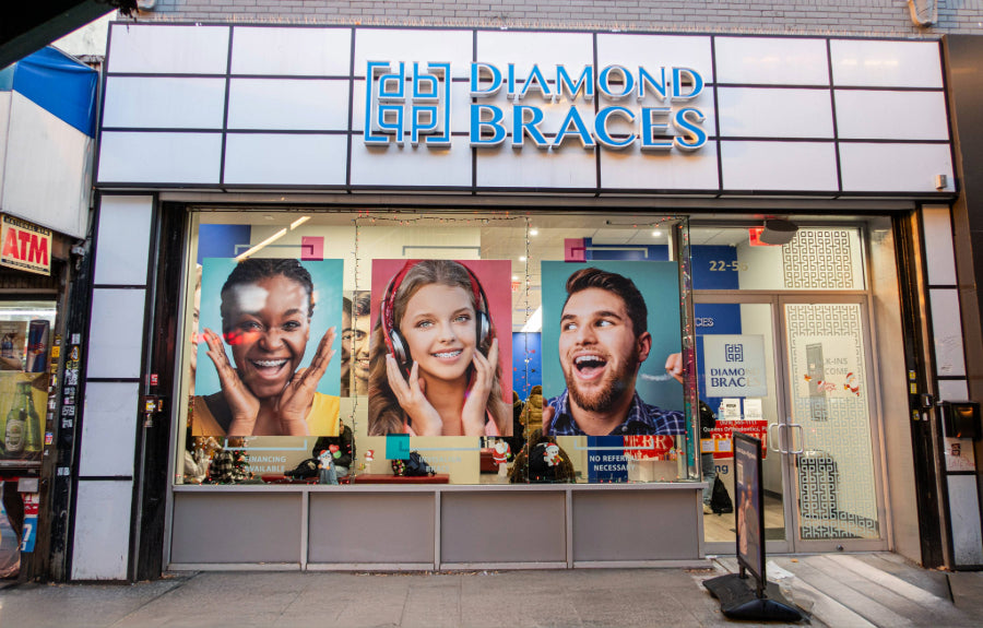 Diamond Braces orthodontist office with large windows and promotional posters on a city street in the Bronx.