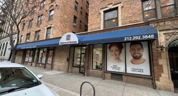 Diamond Braces dental care office store front with blue awning and promotional posters on a city street in East Village, Manhattan.