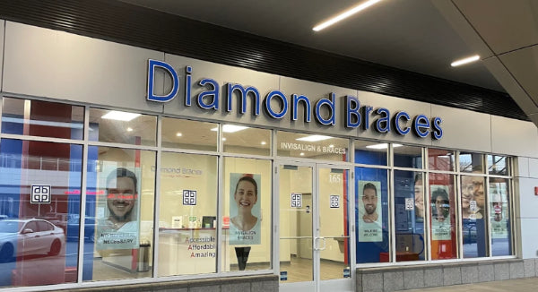 Diamond Braces dental care clinic exterior with large glass windows and visible branding inside a New York City building.