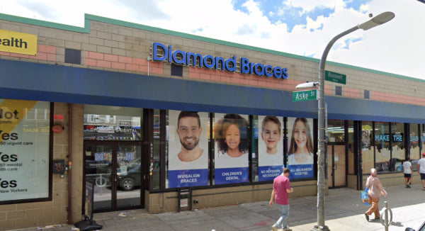 Diamond Braces dental office with promotional posters on a building facade in Jackson Heights.