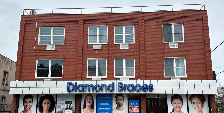 Brick building with 'Diamond Braces' sign and promotional posters on a cloudy day.