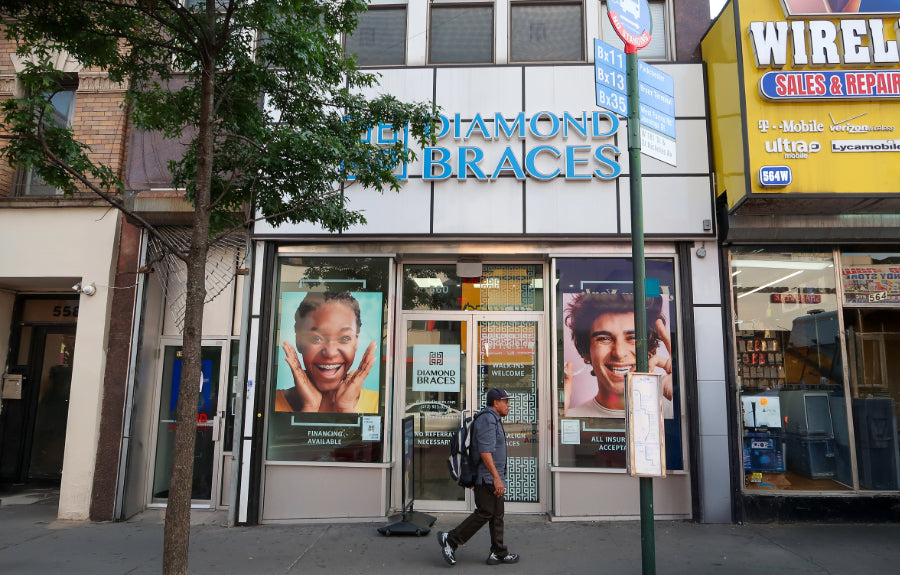 Diamond Braces dental office with advertisements on the windows, surrounded by urban New york elements.