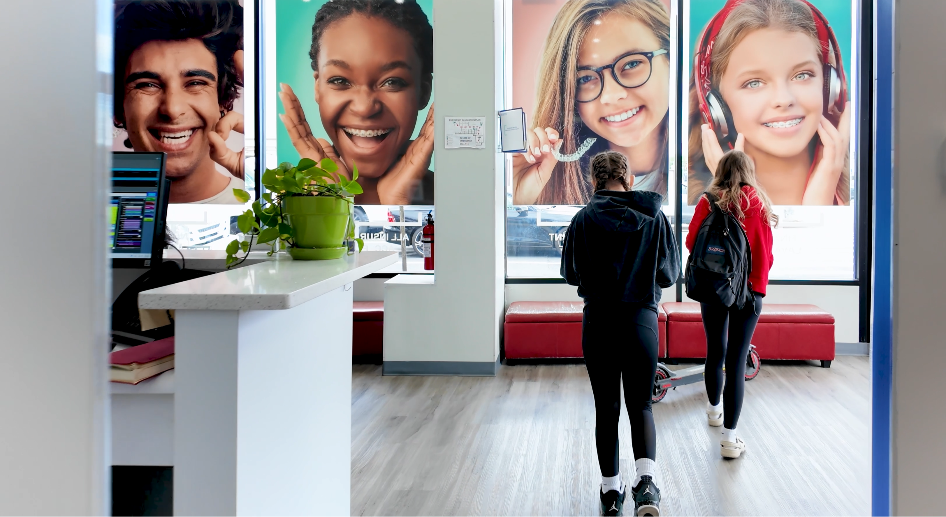Dental care patients walking past a Diamond Braces dentist office with large windows displaying smiling faces.