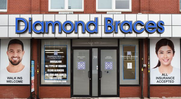 Diamond Braces dentist office with promotional posters on a brick building in Brooklyn, New York.