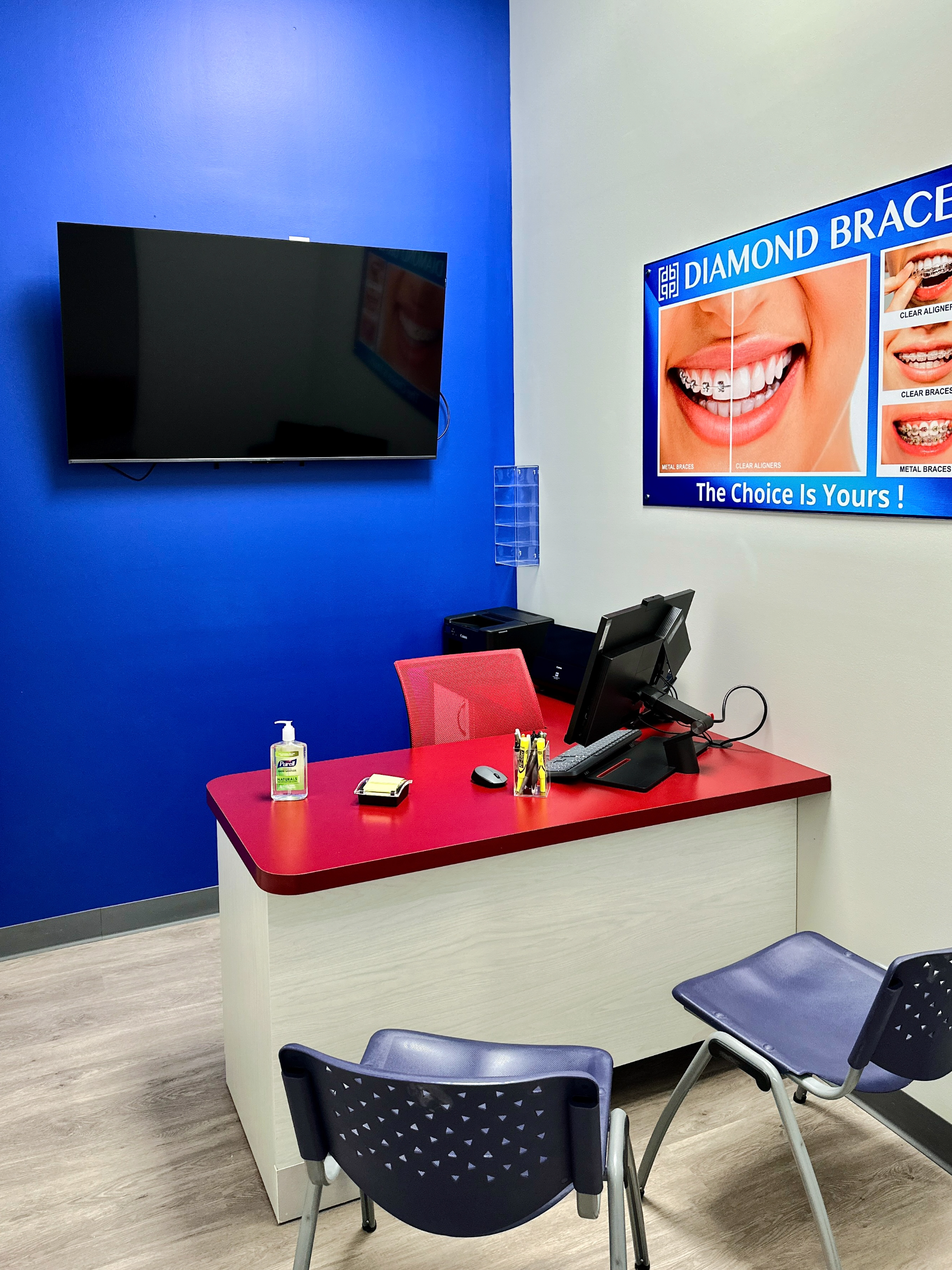 Modern dentist office interior with a reception desk, chairs, and promotional display on the wall for Diamond Braces.