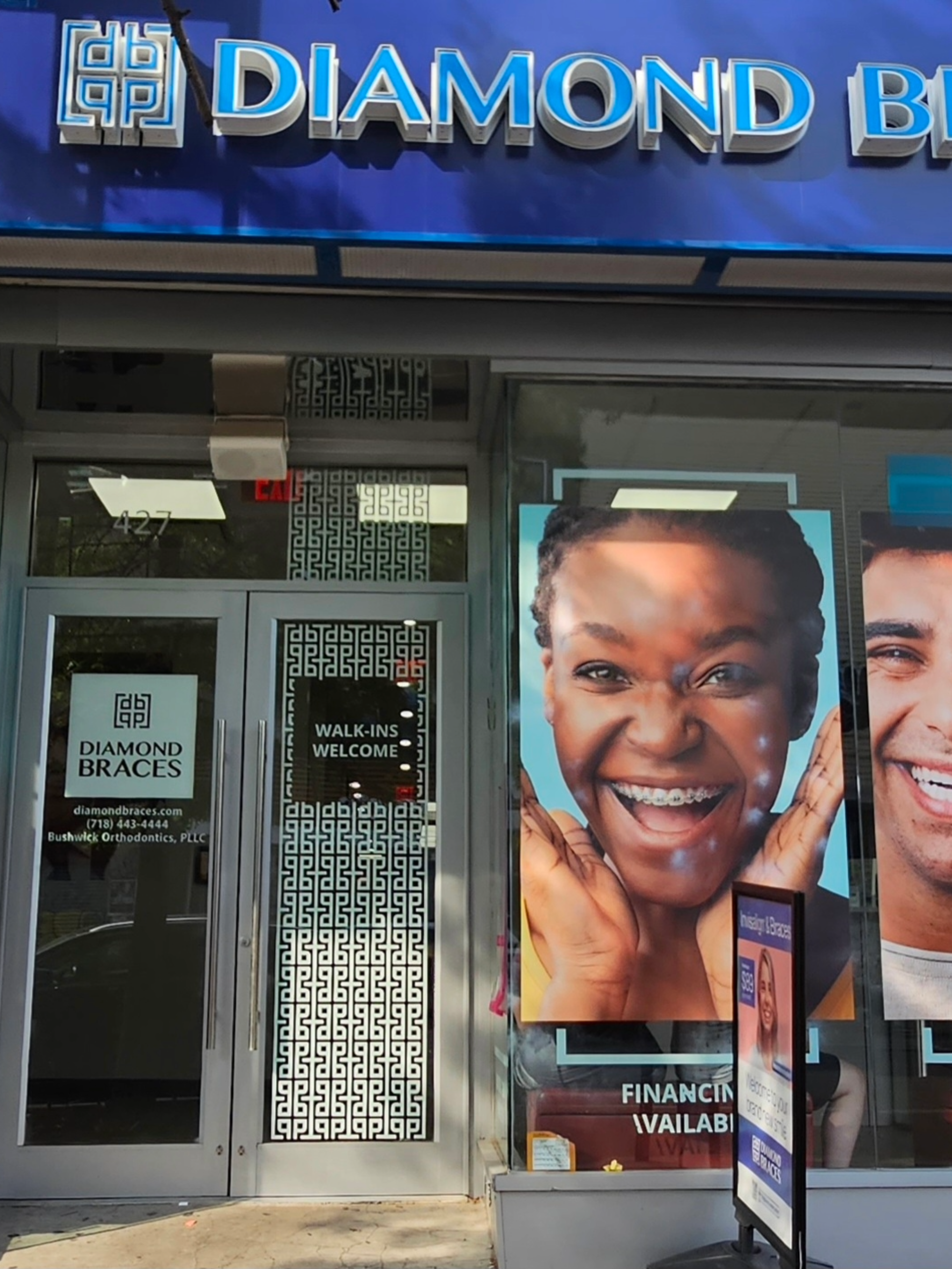 Diamond braces dental office entrance with promotional posters for ceramic braces and clear aligners on the door.