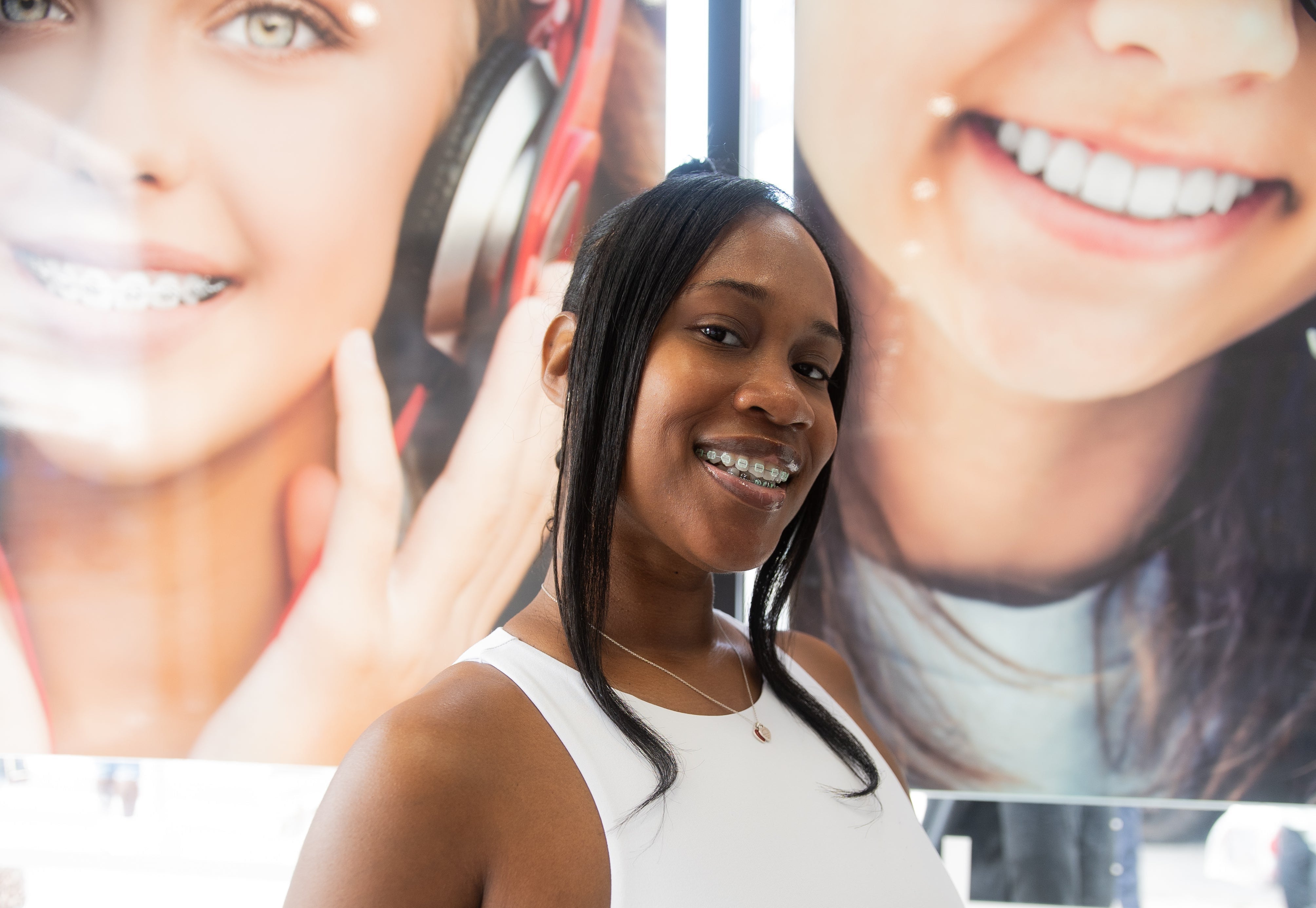 woman with neon adult braces smiling inside dental office