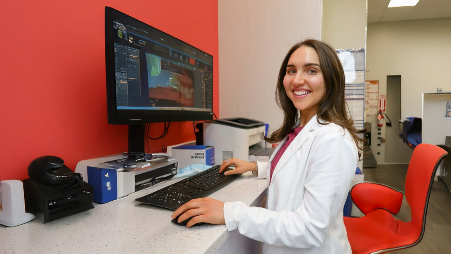 Dental hygienist in a white lab coat using a computer in a diamond braces dental office.